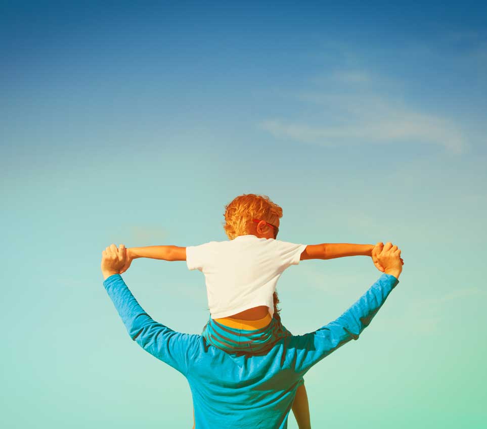 Stock photo of father with son on his shoulders